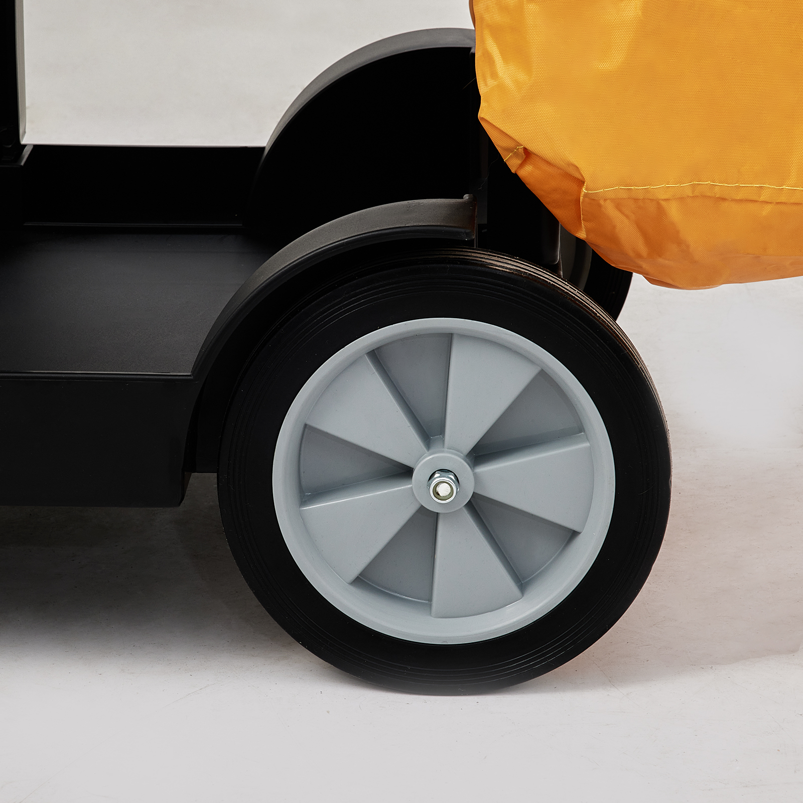 large wheel of a VEVOR janitorial cart with black frame and yellow bag, close-up on a light background.