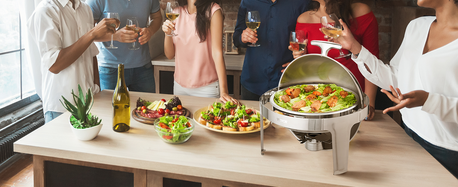 group of friends enjoying wine and canapés around a VEVOR roll top chafing dish on a wooden table.
