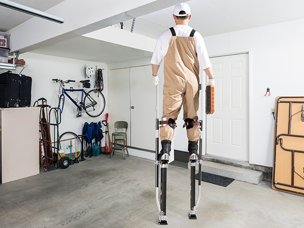 рабочий на гипсокартонных сваях VEVOR красит стены в гараже и устанавливает потолок в строящемся помещении.