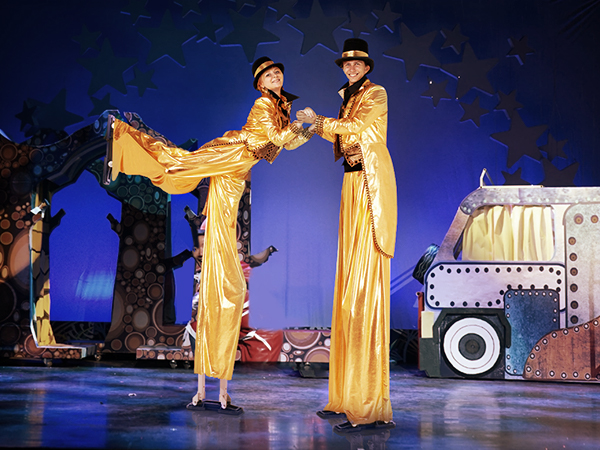 исполнители в золотых костюмах на ходулях перед красочной сценой, одетые в ходули из гипсокартона VEVOR.