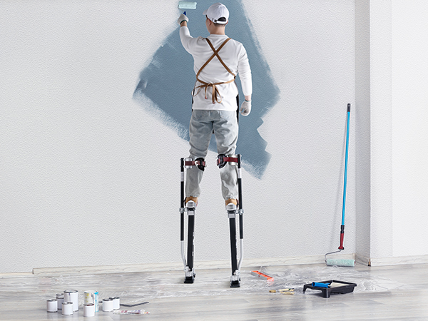 маляр, использующий сваи из гипсокартона VEVOR для покраски стены в окружении малярных инструментов и расходных материалов.