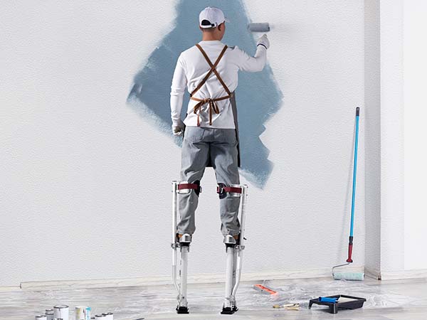 dailininkas naudojant VEVOR gipso polių dažų sienos, apsuptas dažymo įrankiai ir reikmenys.