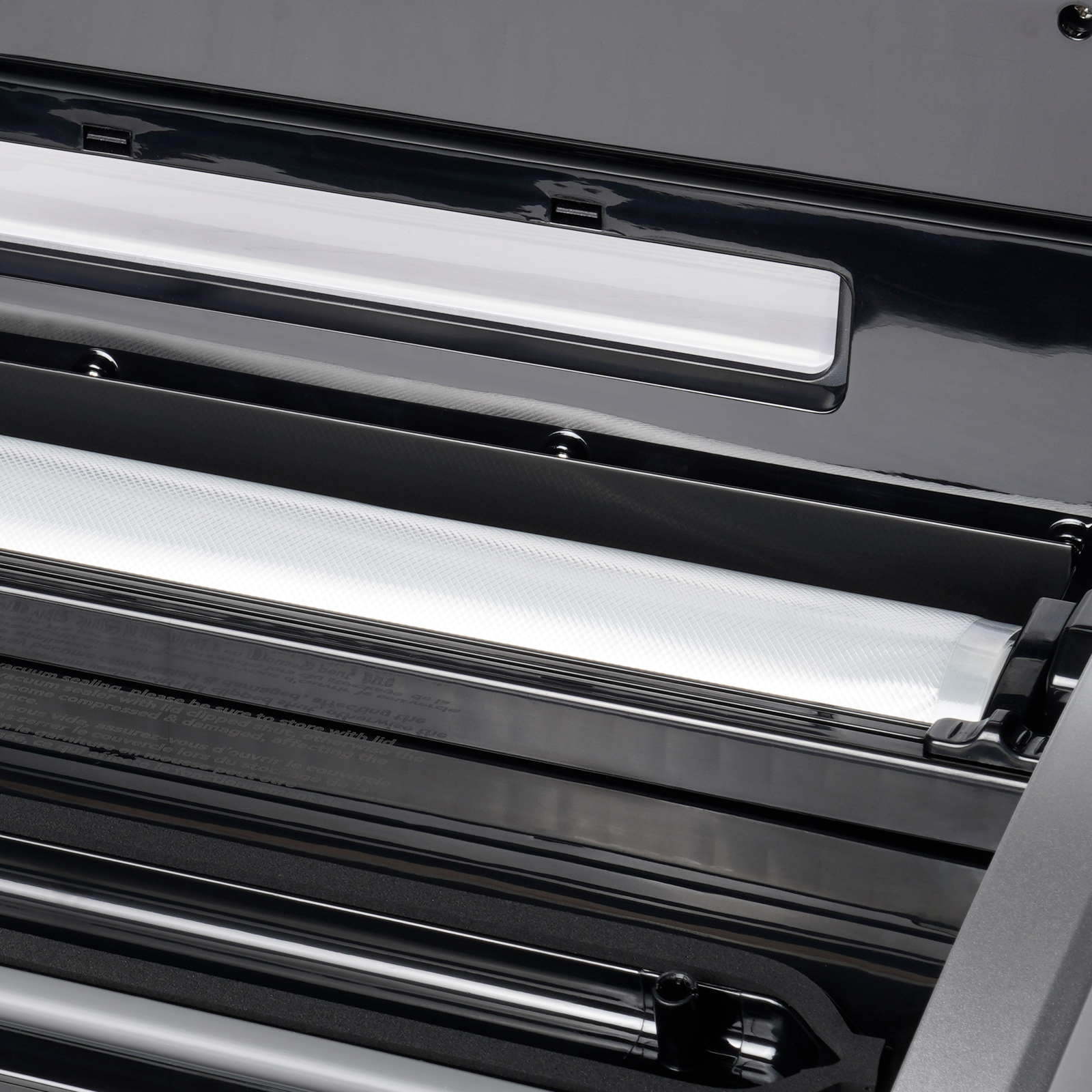 interior view of VEVOR vacuum sealer showcasing sealing strip and bag storage compartment.