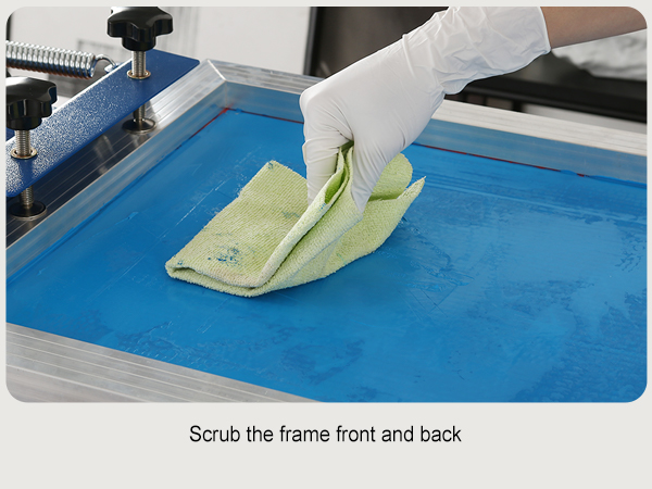 gloved hand cleaning a blue screen on a VEVOR screen printing kit with a green cloth.