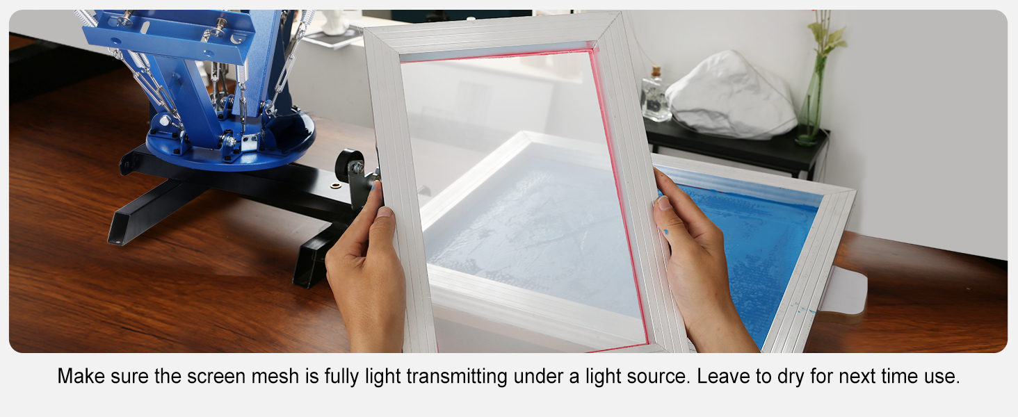 hands holding a mesh frame next to a printing machine in a VEVOR screen printing kit setup.