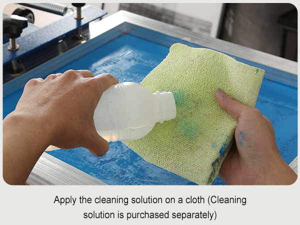 hands cleaning a screen with a cloth and solution, part of the VEVOR screen printing kit.