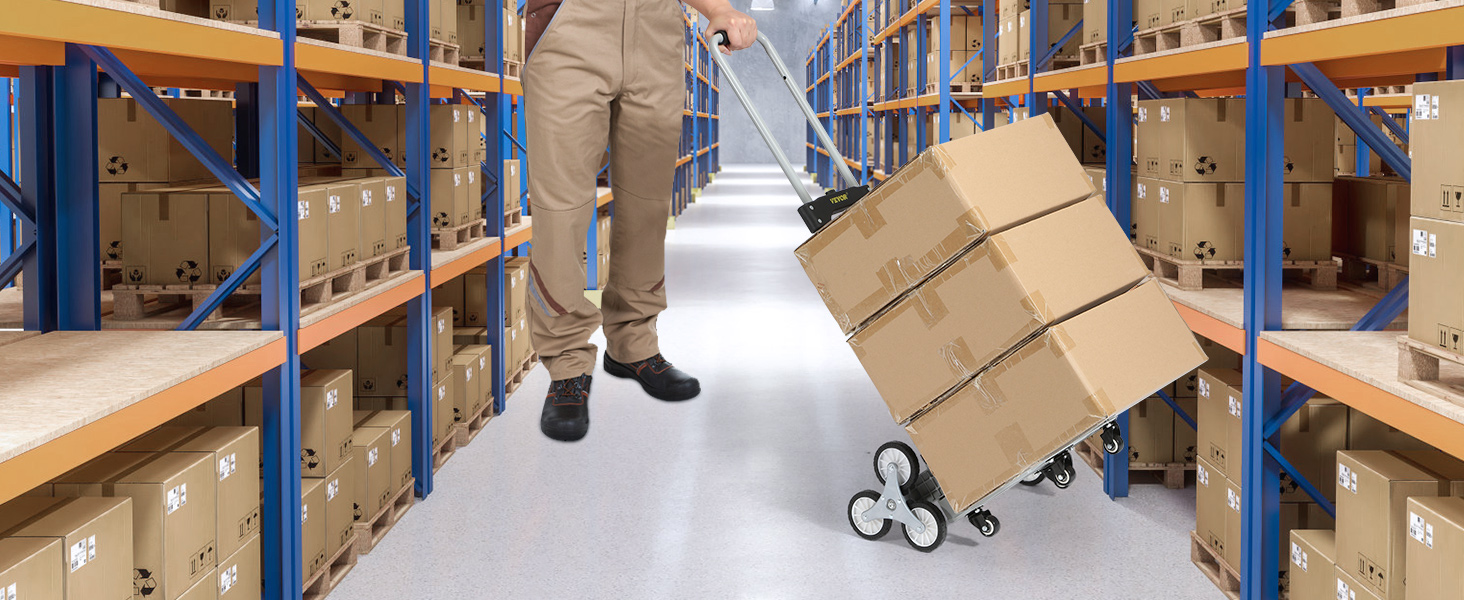 warehouse worker using VEVOR stair climbing cart to move stacked boxes between shelves.