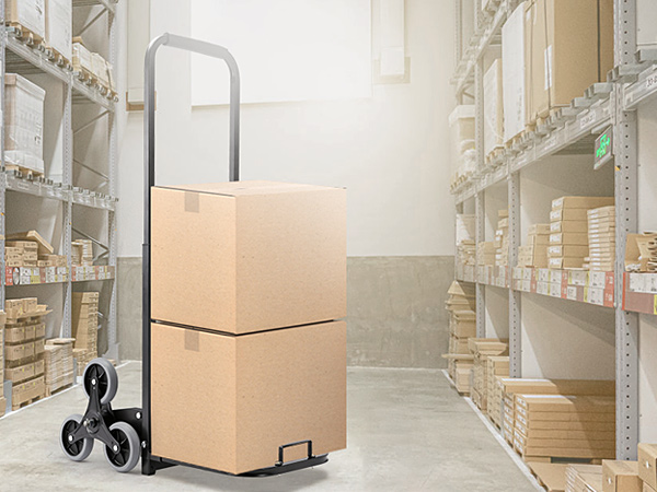 warehouse with VEVOR stair climbing hand truck moving large boxes amidst organized shelves.