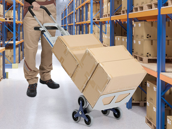 sandėlio darbuotojas naudoja VEVOR laiptų alpinistinės krepšelį perkelti dėžės per metalinės lentynos alsuoja paketai.