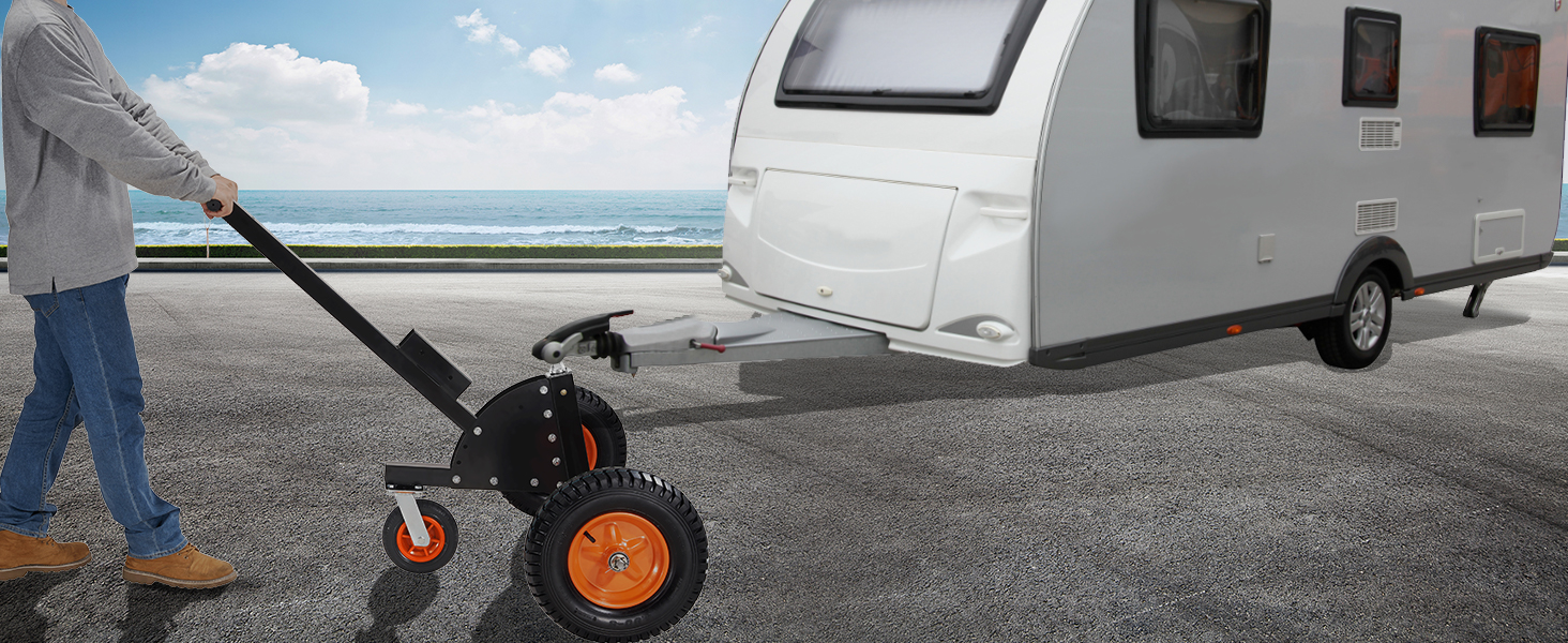 Vīrietis izmanto VEVOR piekabes ratiņus, lai manevrētu lielu baltu dzīvojamo piekabi netālu no piejūras ceļa.