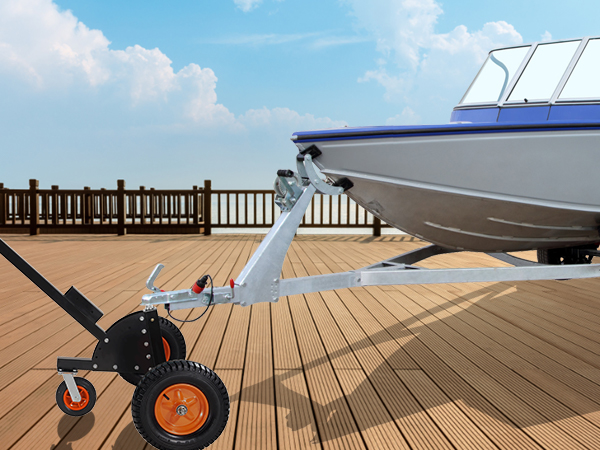 Vīrietis izmanto VEVOR piekabes ratiņus, lai pārvietotu laivu uz koka klāja ūdens tuvumā.