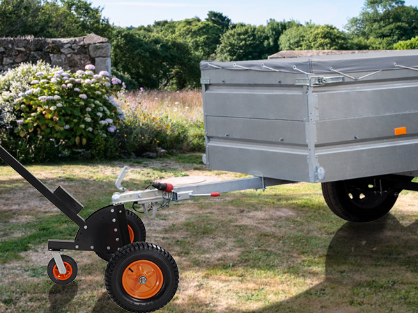 Vīrietis izmanto VEVOR piekabes ratiņus, lai pārvietotu piekabi pāri zāļainam pagalmam, fonā ziediem.