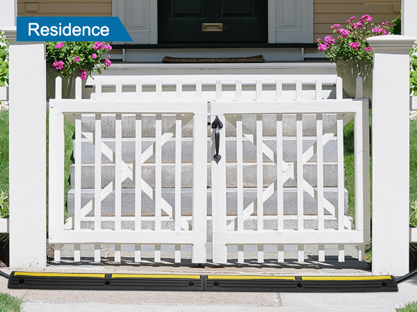white picket fence with a VEVOR cable protector ramp and vibrant pink flowers.