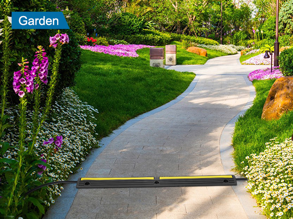 VEVOR cable protector ramp in a garden path with flowers, greenery, and outdoor lighting.
