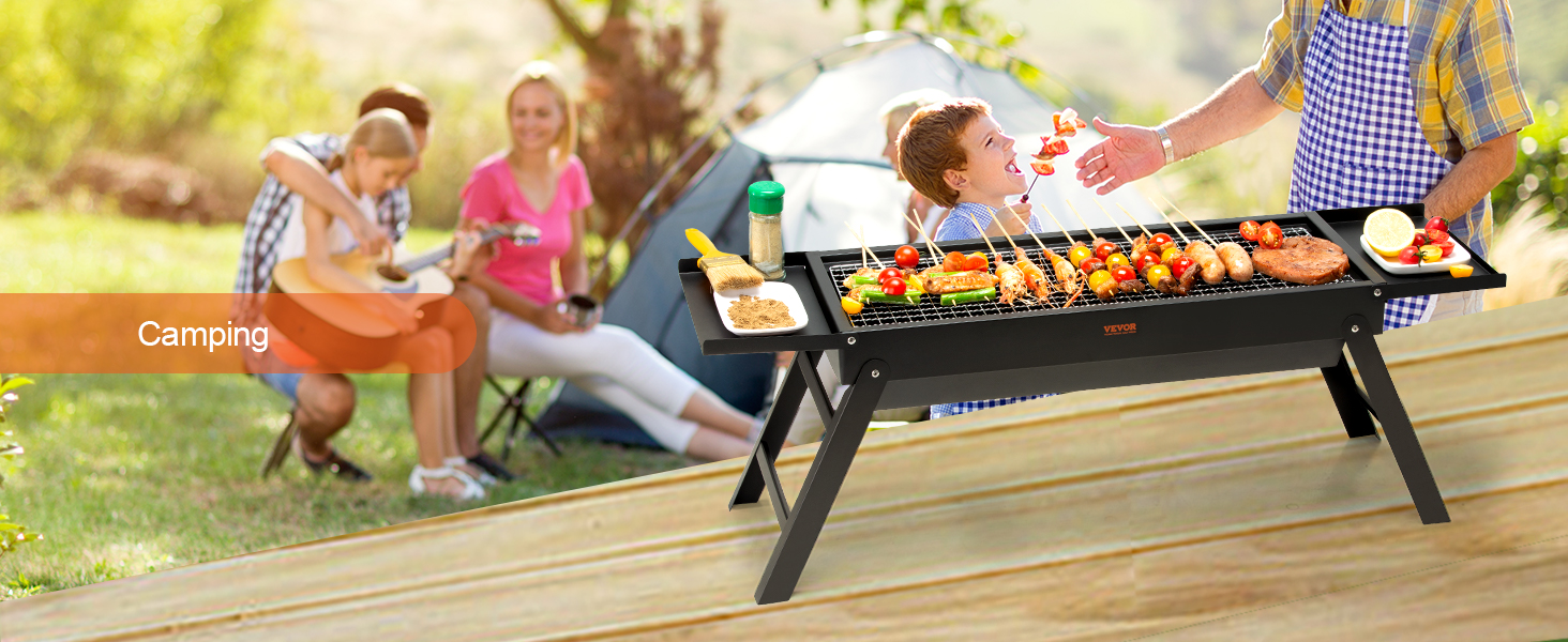 VEVOR portable charcoal grill at a camping site with skewers, spices, and a tent in the background.