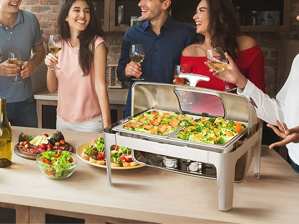 люди наслаждаются едой и напитками вокруг блюда VEVOR для обжаривания, наполненного горячими закусками на вечеринке.