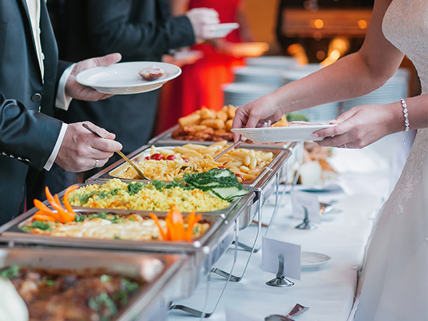 guests serving food from a VEVOR chafing dish set at a buffet, featuring various colorful dishes.