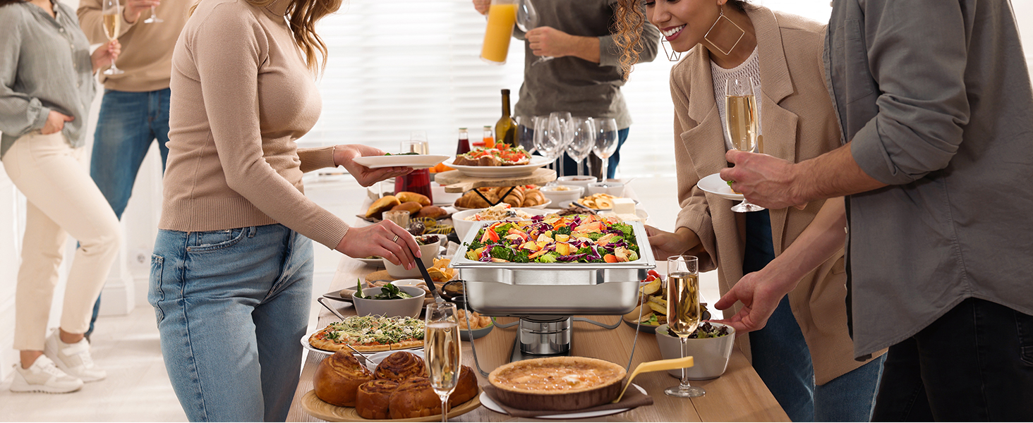 buffet spread with salad in a VEVOR chafing dish, surrounded by people serving food and drinks.
