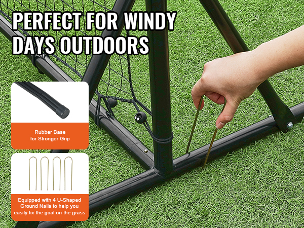 hand securing VEVOR soccer rebounder net with u-shaped ground nails, showing triangular rubber base.