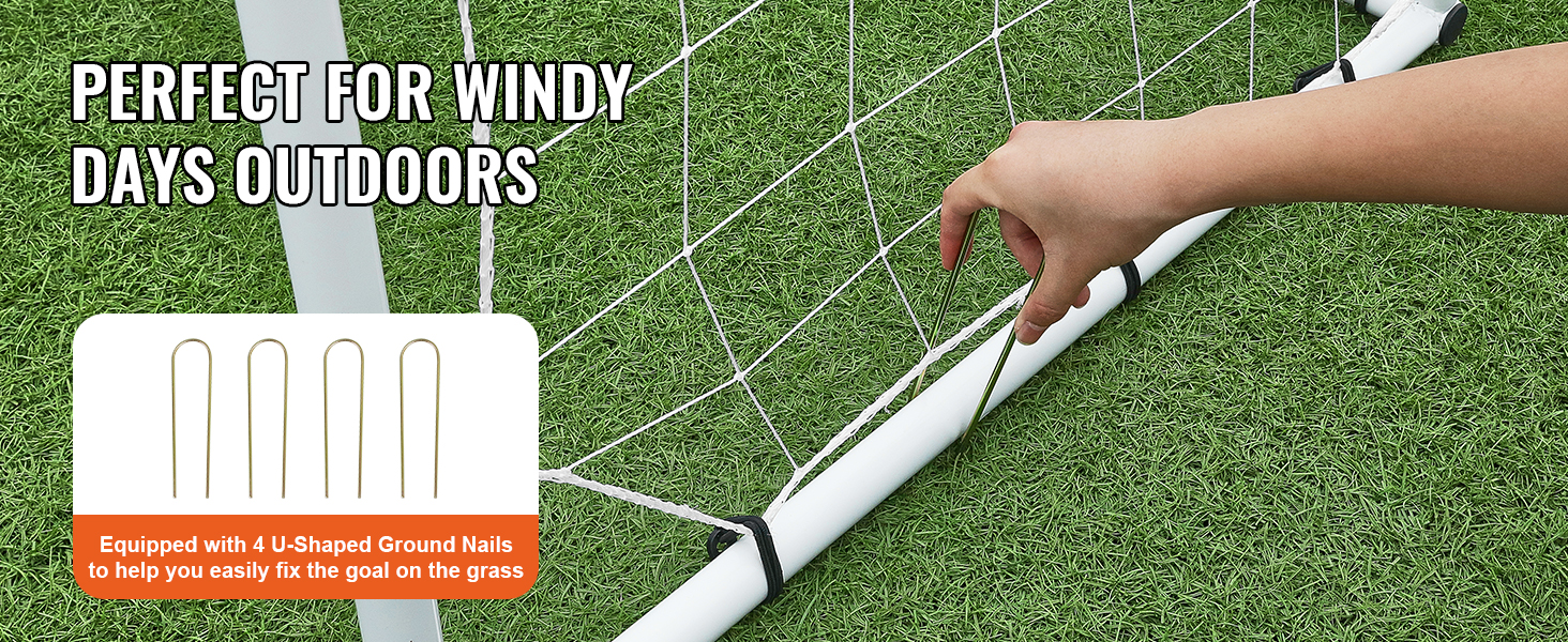 hand securing VEVOR soccer rebound trainer with u-shaped ground nails on grass for stability in windy conditions.