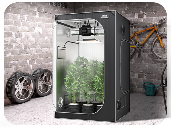 VEVOR grow tent in a garage with plants, green grill, spare tires, orange bike, desk, and chair.