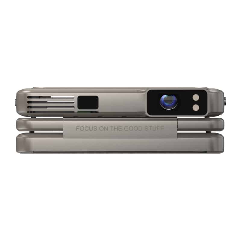 Close-up of a silver handheld projector with a blue lens on the right and the phrase 'FOCUS ON THE GOOD STUFF' along the middle panel.